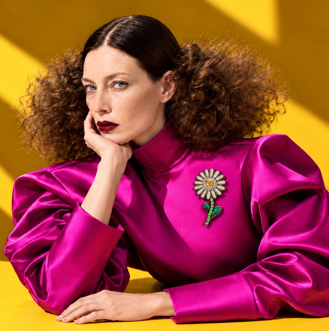 Broche fleur blanche au cœur jaune et à la tige verte, portée sur une blouse fuchsia, sur fond jaune — Céleste Mogador.
